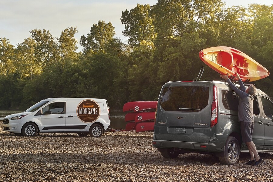 The versatile 2023 Ford Transit Connect Passenger Wagon in Magnetic with a man loading kayaks