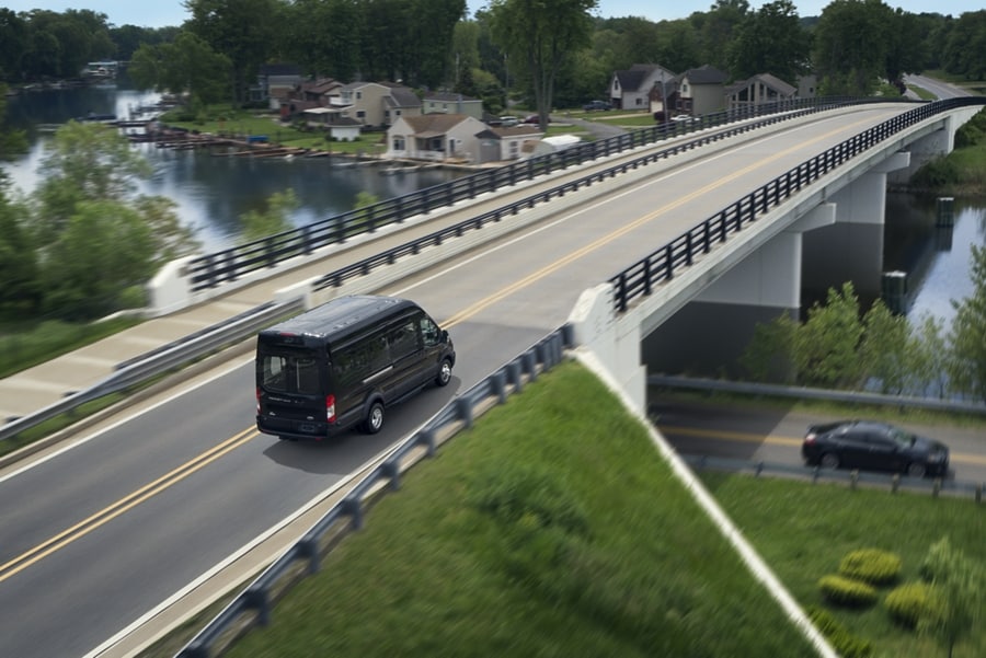 Vista superior de una Van ​​​​​​​Ford Transit® Passenger 2023 en un puente por arriba de una autopista​​​​​​​