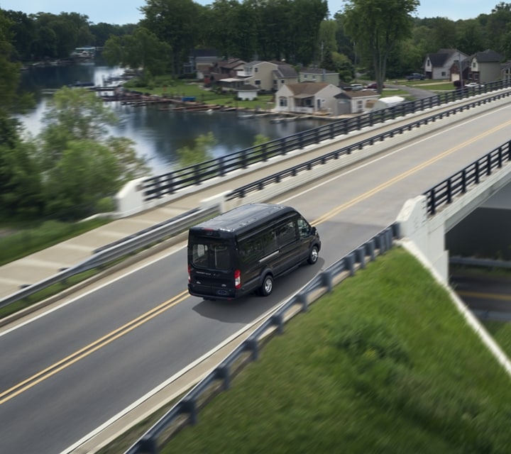 A 2023 Ford Transit® Van being driven over a bridge
