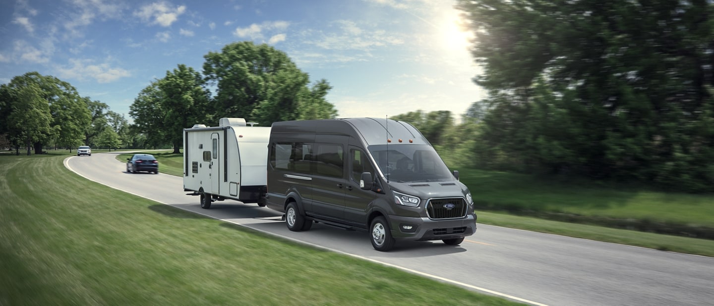 A 2023 Ford Transit® van with a medium-sized camper in tow