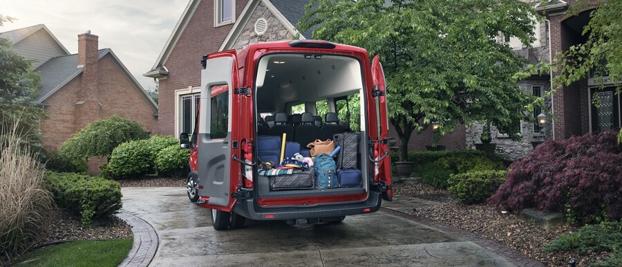 The rear of a 2023 Ford Transit® van with the doors open and cargo inside