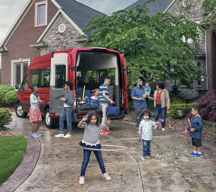 Un grupo de niños jugando enfrente de una van Ford Transit® 2023 con las puertas de carga abiertas
