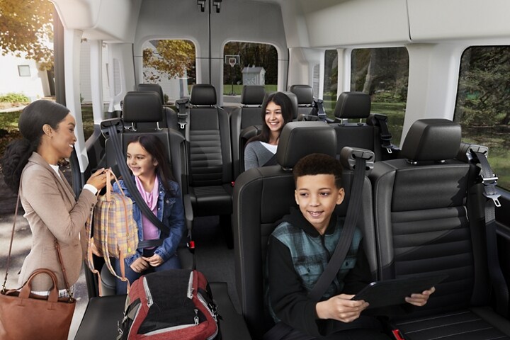 Una niña y un niño usan dispositivos con Wi-Fi en el asiento trasero de un vehículo Ford