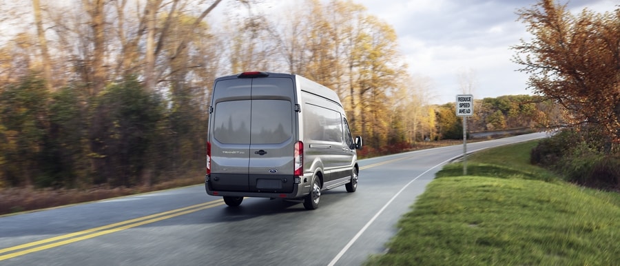 A 2023 Ford Transit® van being driven down a road