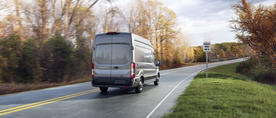 Una van Ford Transit® 2023 bajando por un camino