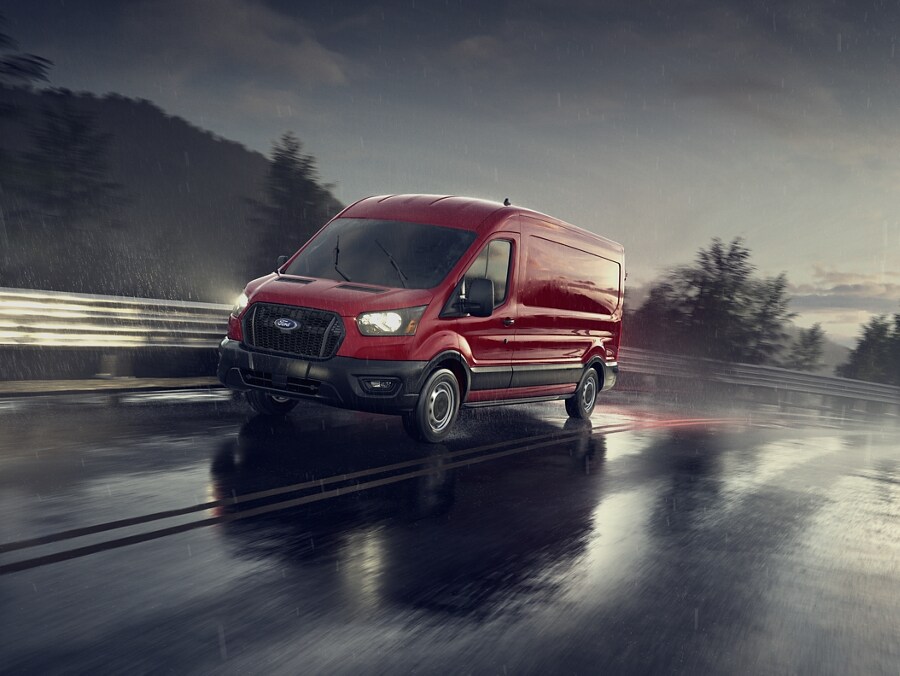 A 2024 Ford Transit® van being driven on a wet curved road