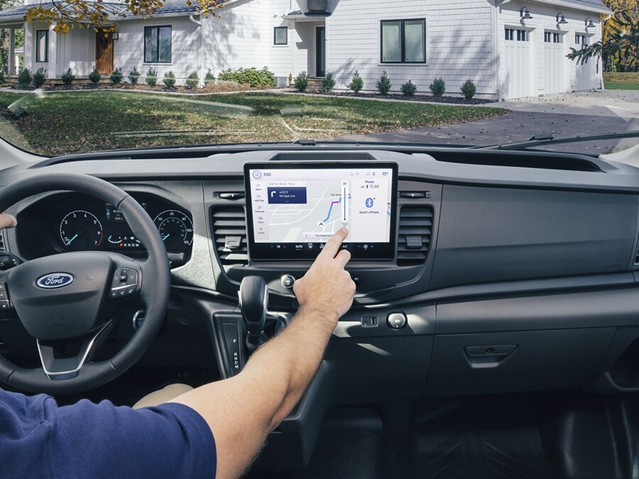 A man inside of a 2024 Ford Transit® van utilizing the 12-Inch Touchscreen